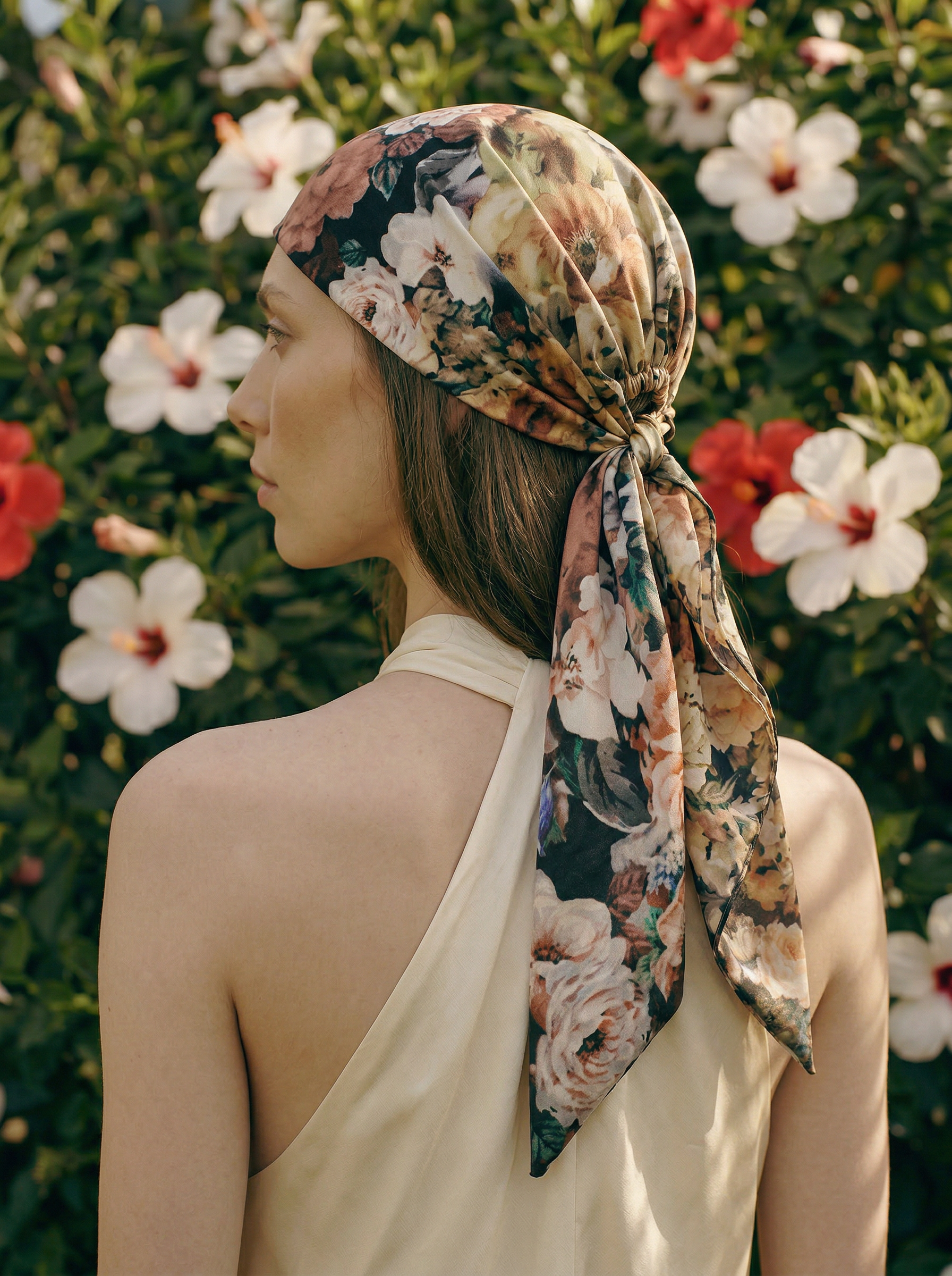 Woman wearing a blush floral headscarf with a garden background