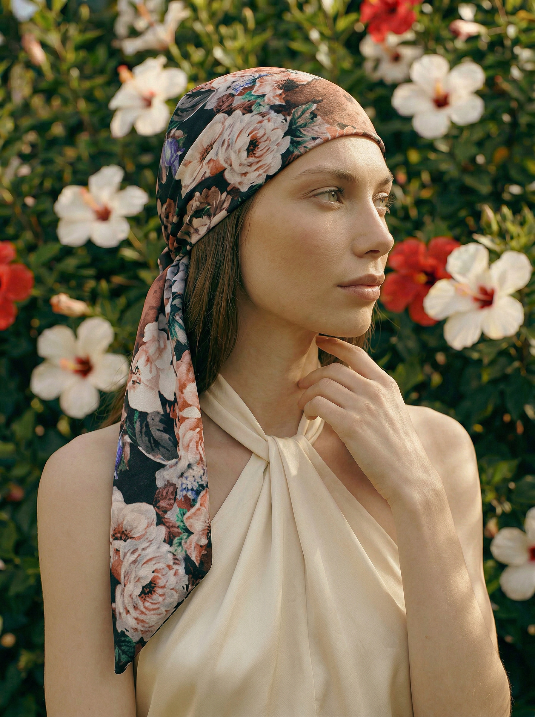 Woman wearing a blush floral headscarf with a garden background