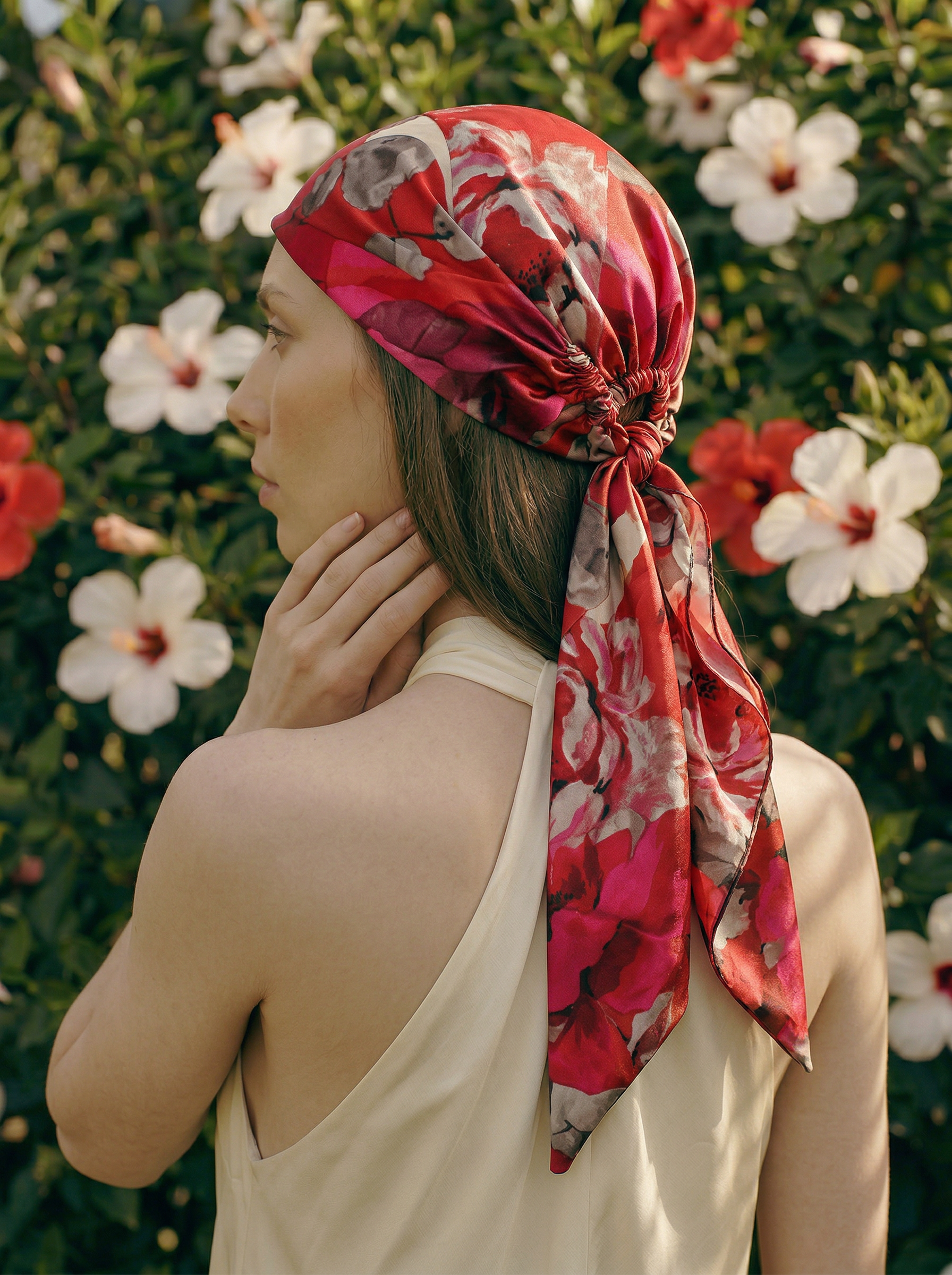 Woman wearing a red floral headscarf with a floral background